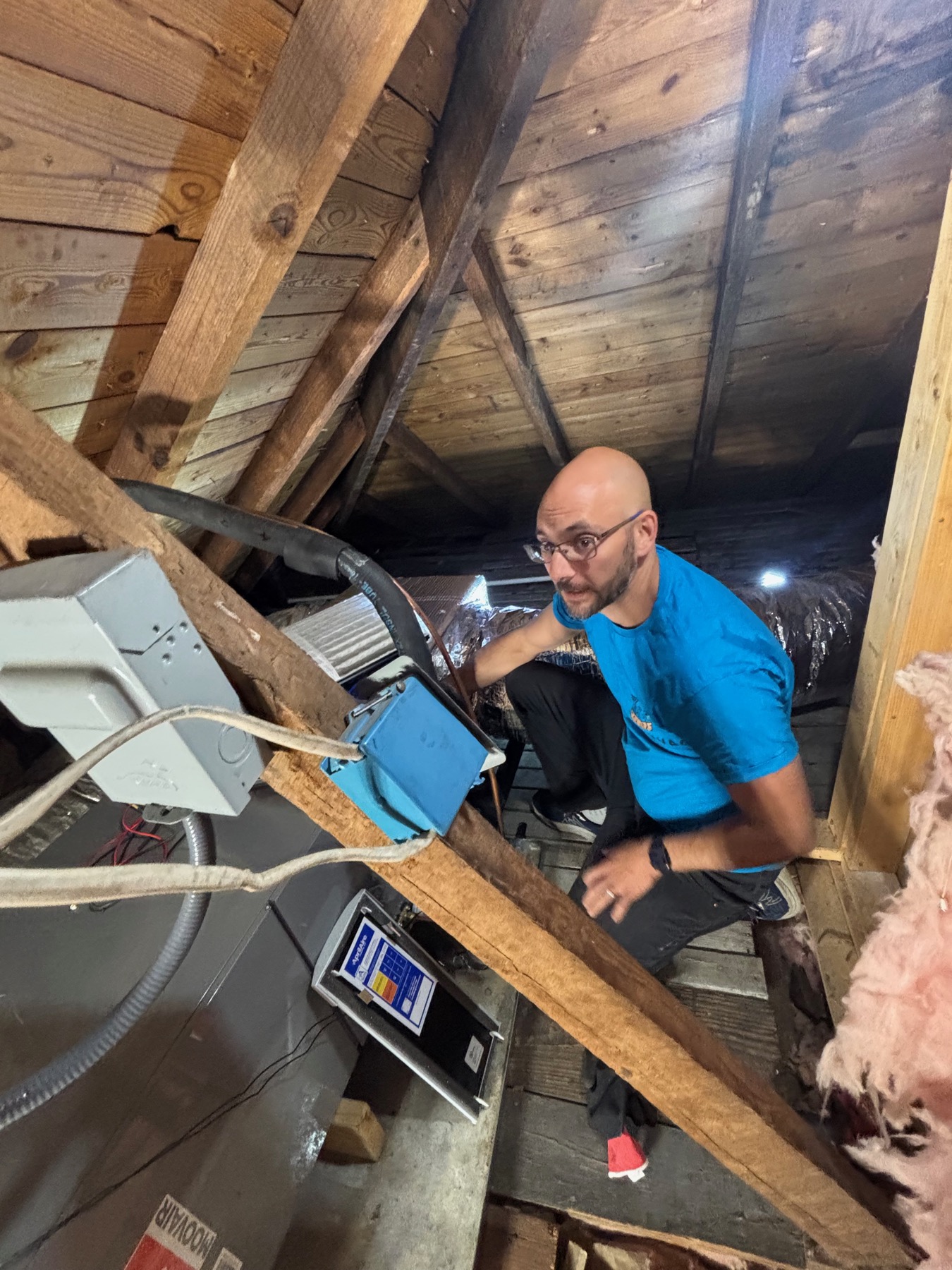 OCD HVAC technician inspecting attic HVAC equipment during diagnostic service.